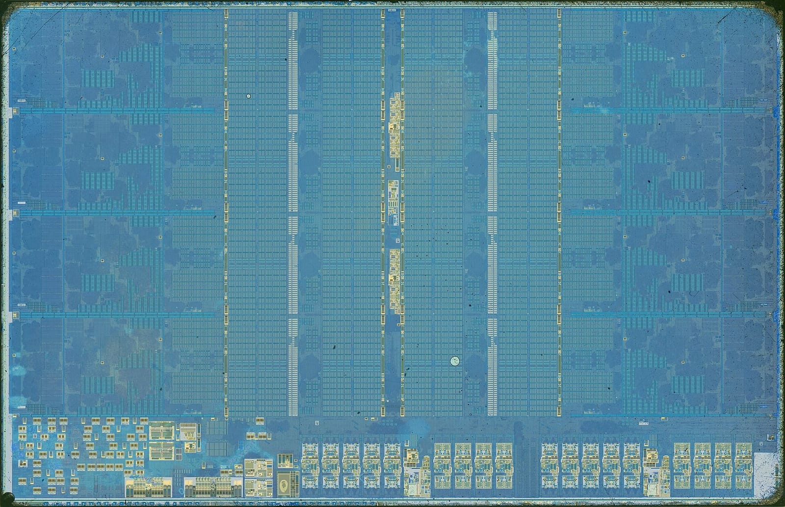 Microscope photo of an AMD Zen 4 compute die: four core tiles down each side edge, and finely gridded memory arrays filling the middle