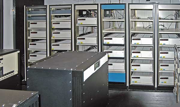 Rows of equipment racks holding many identical rack-mounted cesium-beam clocks