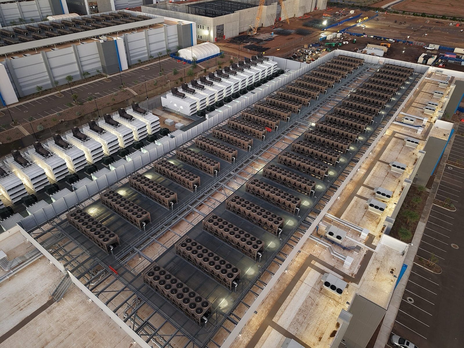 Aerial view of a data centre roof covered in rows of large cooling units, with a line of backup generators along one side