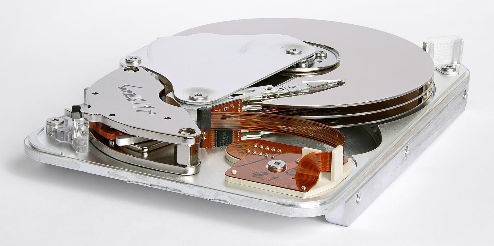 The inside of an opened hard disk drive: stacked mirror-like platters and a read-write head arm reaching across them