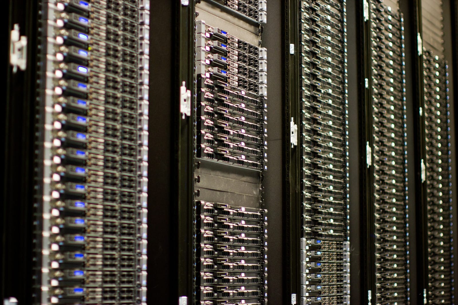A row of data-centre racks full of servers with blue status lights