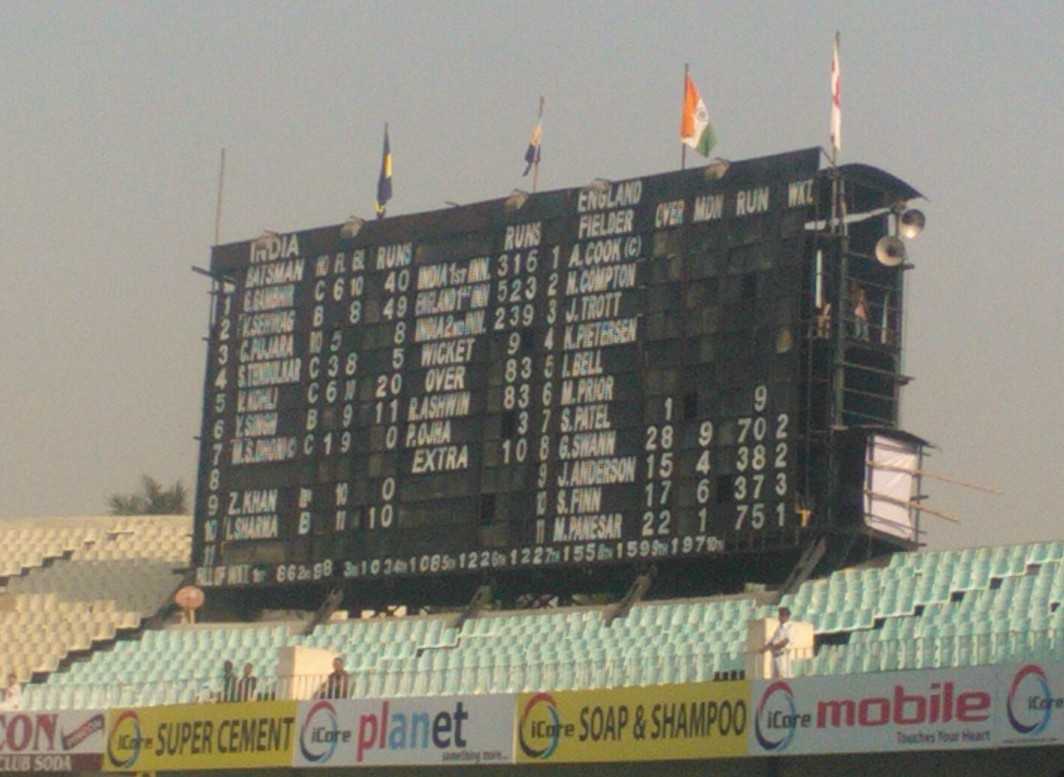 The large hand-operated scoreboard at Eden Gardens, showing batting and bowling figures for India and England